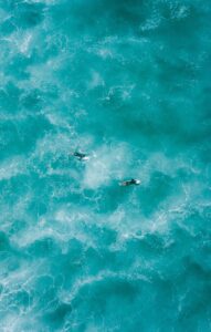 two people surfing on water
